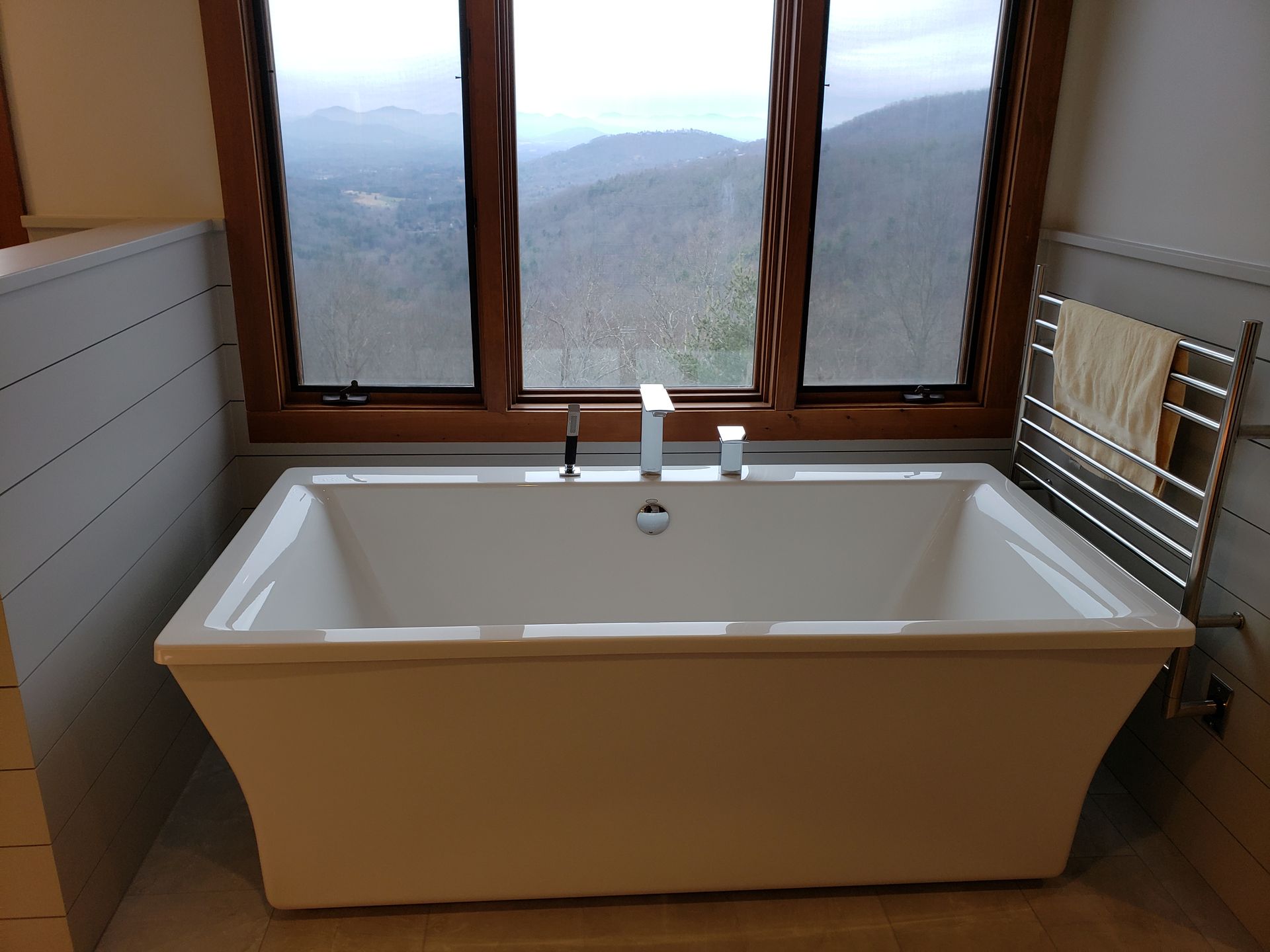 A bathtub in a bathroom with mountains in the background