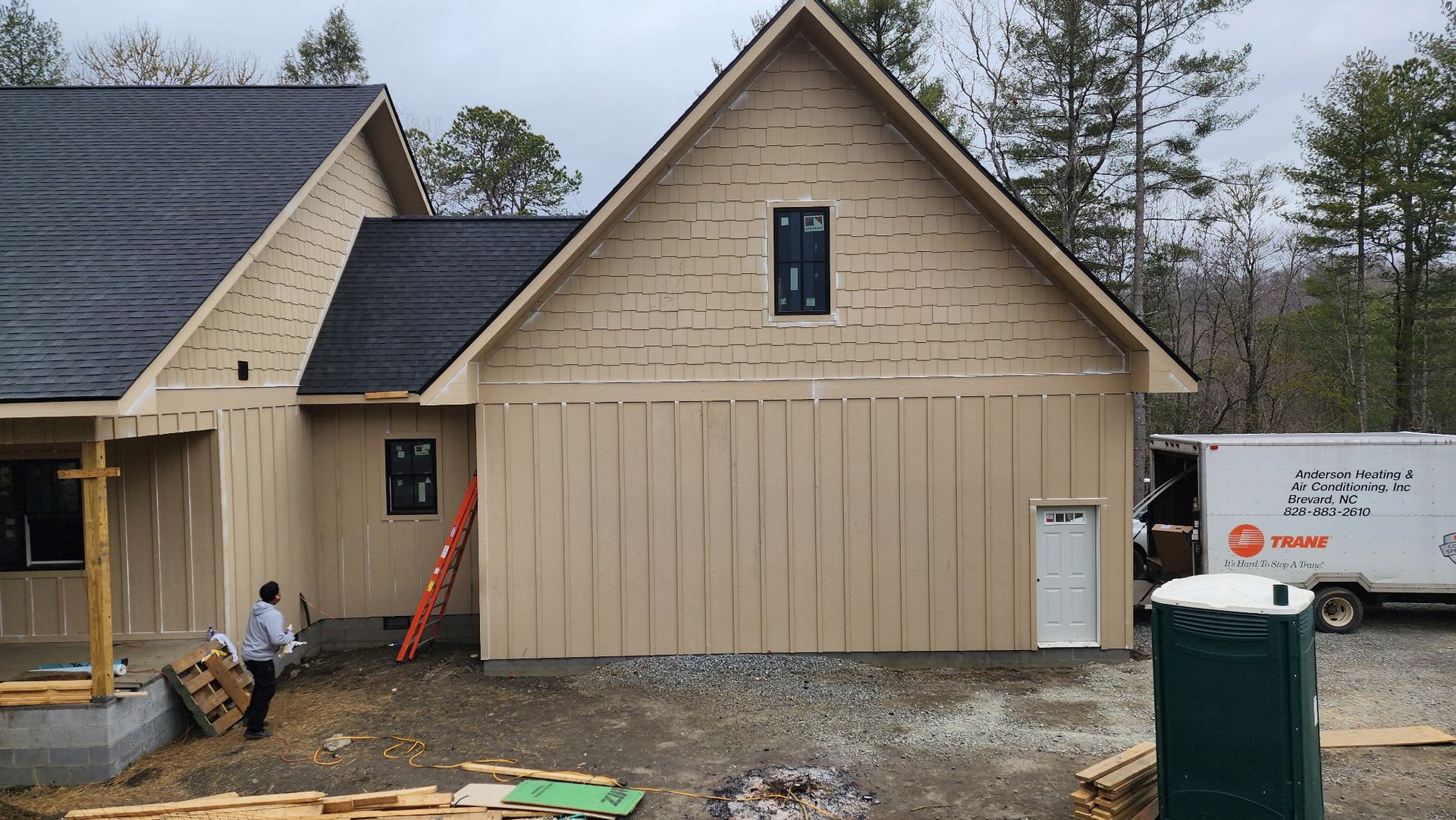 A man is standing in front of a house under construction.