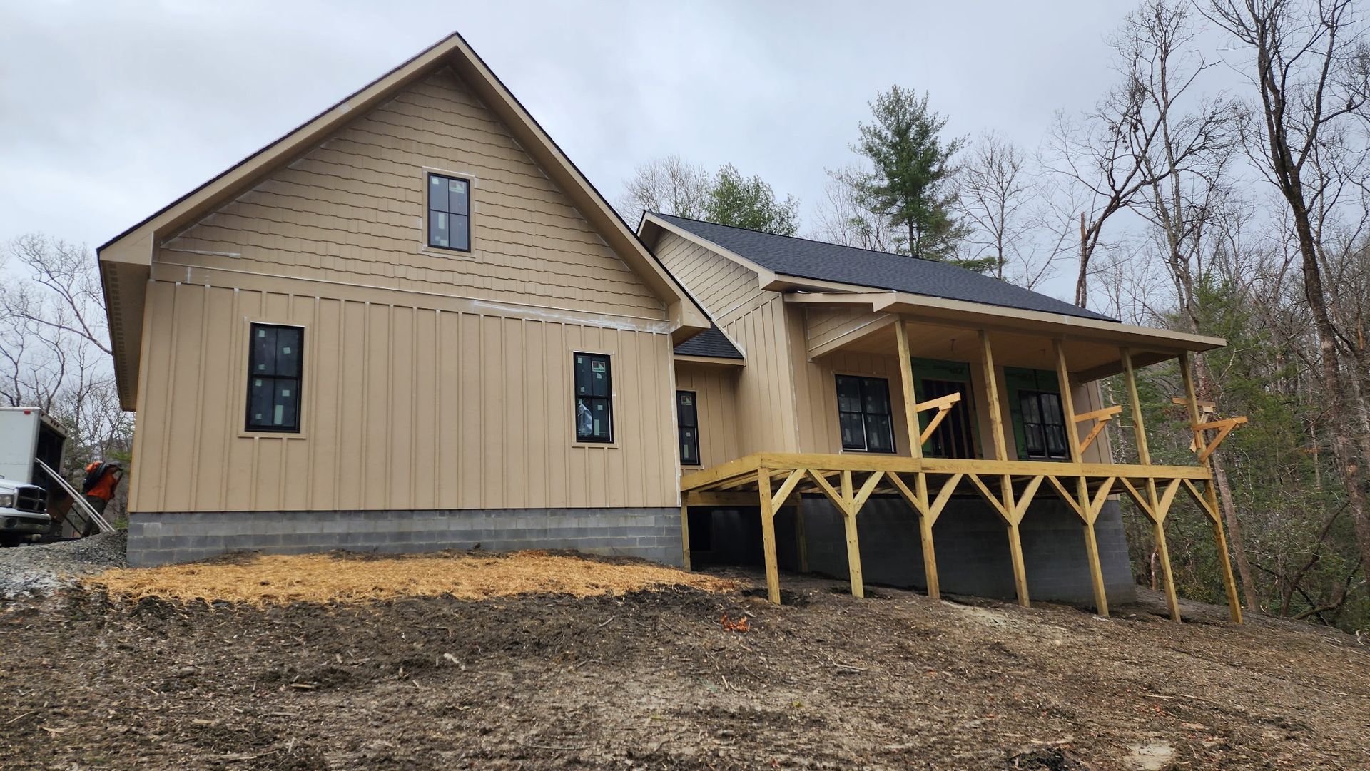 A house is being built in the woods with a large porch.