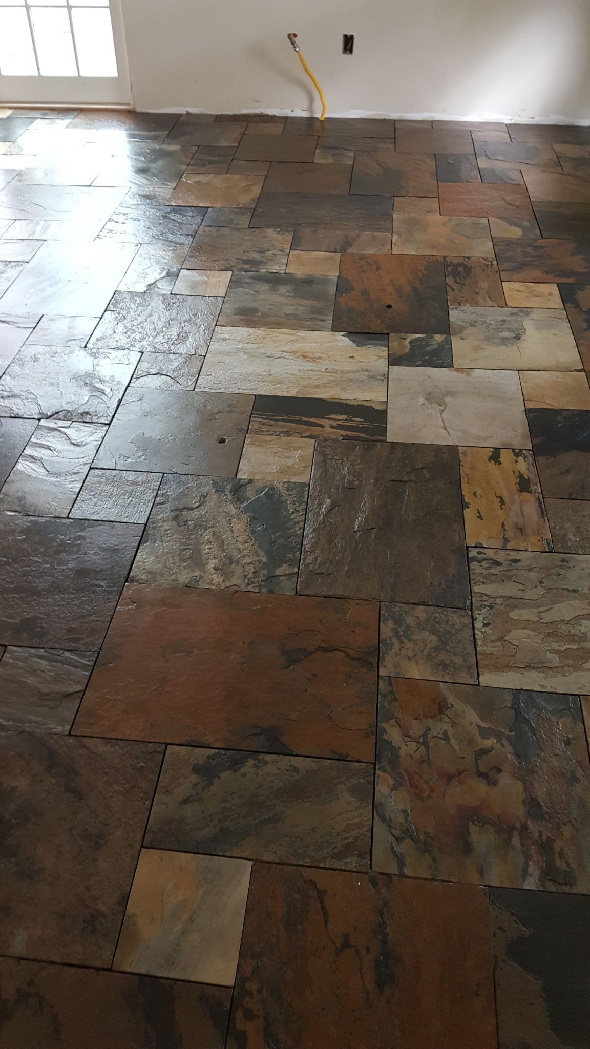 A room with a tiled floor and a window.