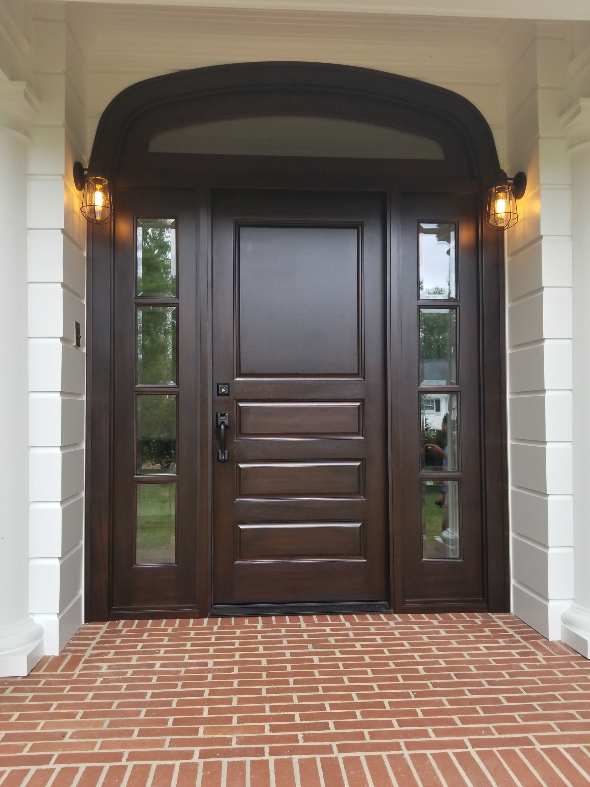 A large wooden door with a brick walkway in front of it