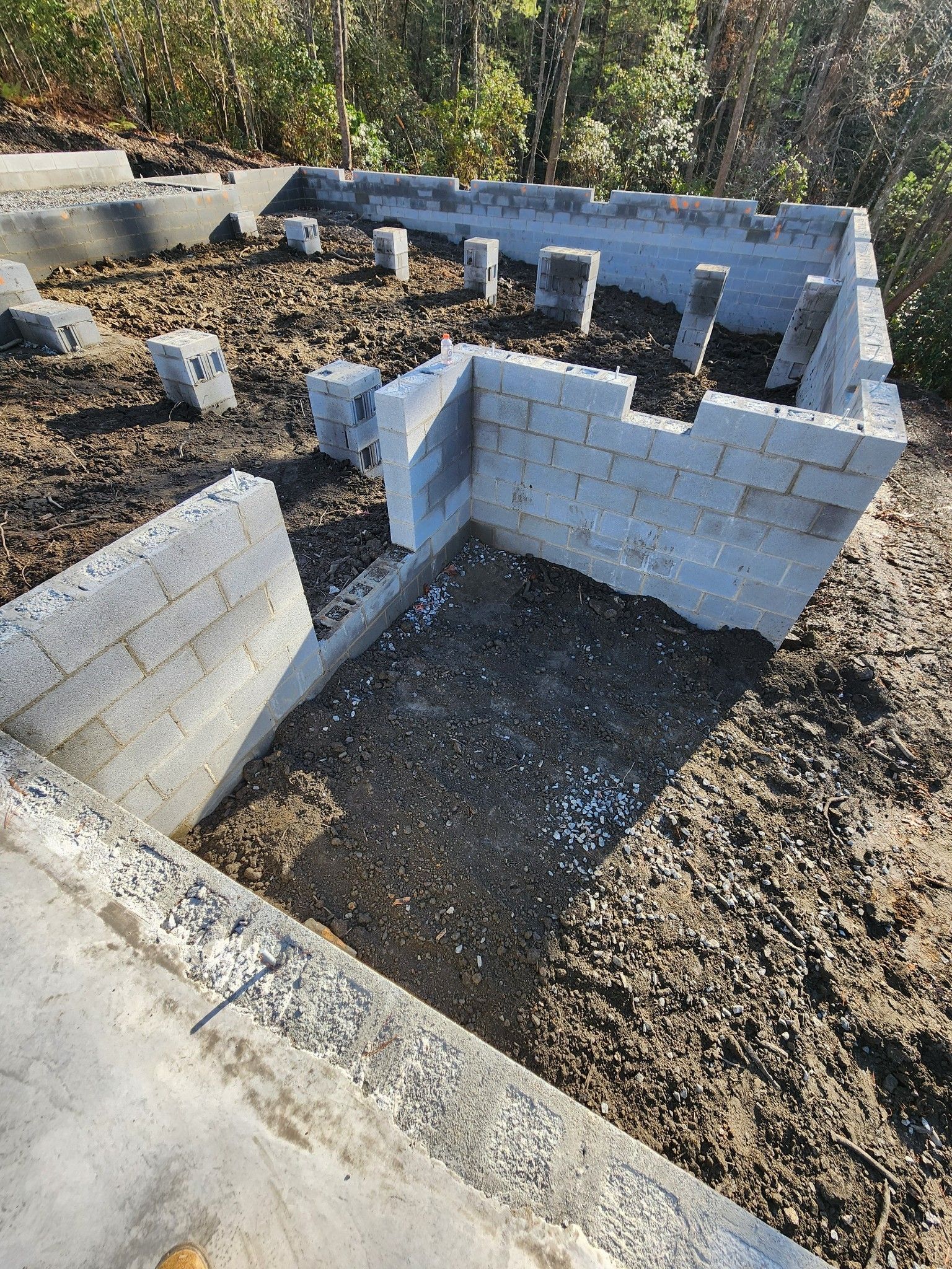 A brick wall is being built on top of a pile of dirt