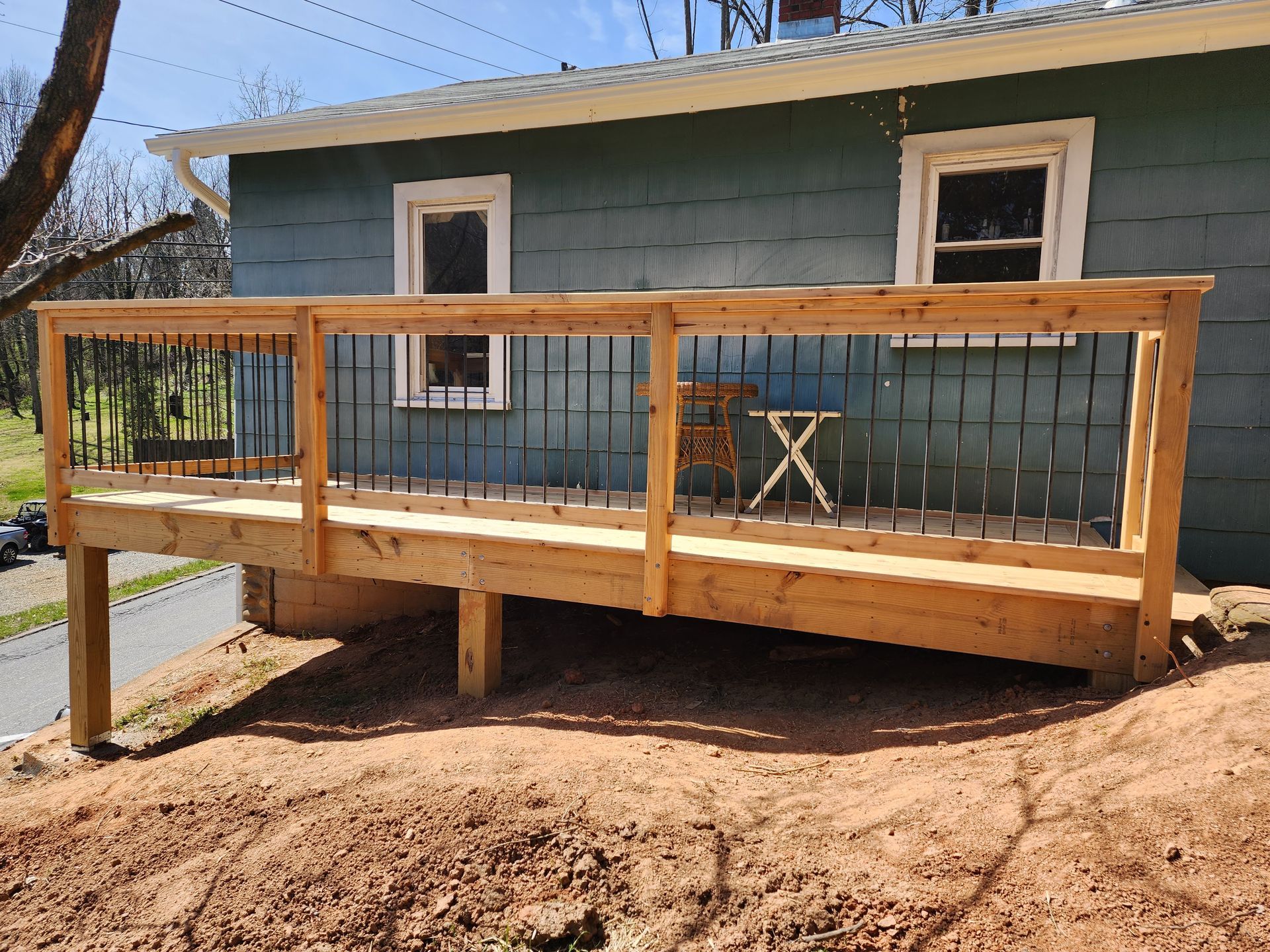 A wooden deck is sitting in front of a blue house