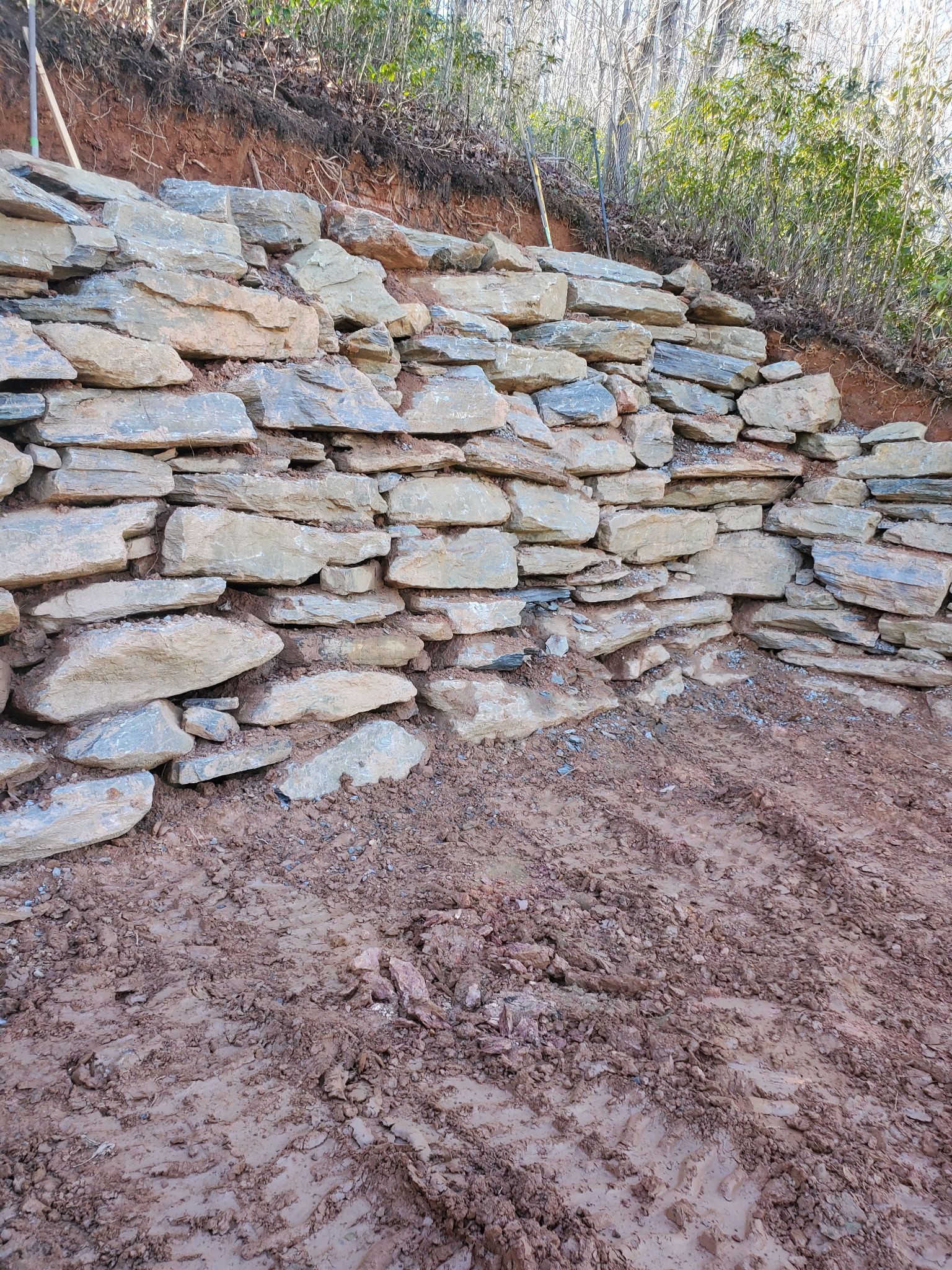 A large pile of rocks is sitting on top of a dirt hill