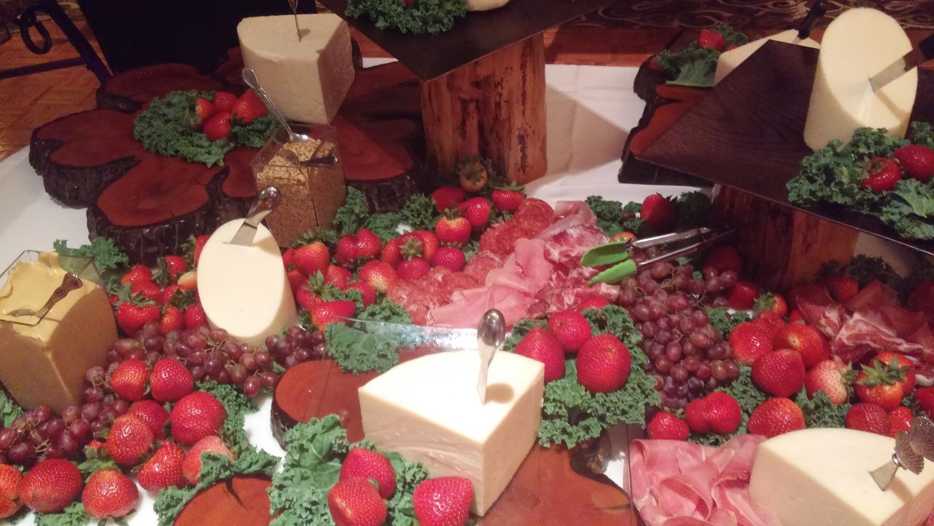 Strawberries and desserts arranged around lit candles on a decorative table centerpiece