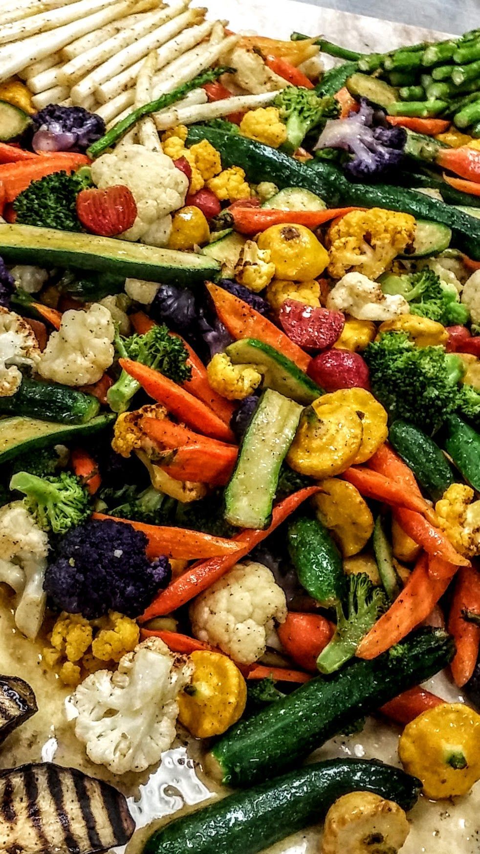 Colorful roasted mixed vegetables including carrots, peppers, zucchini, cauliflower, and green beans on a tray
