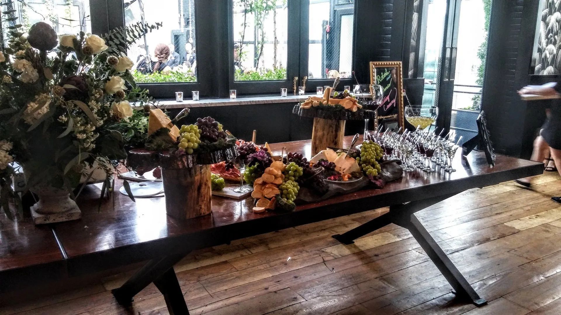 Decorated wooden dining table with floral arrangements and candles in a sunlit room
