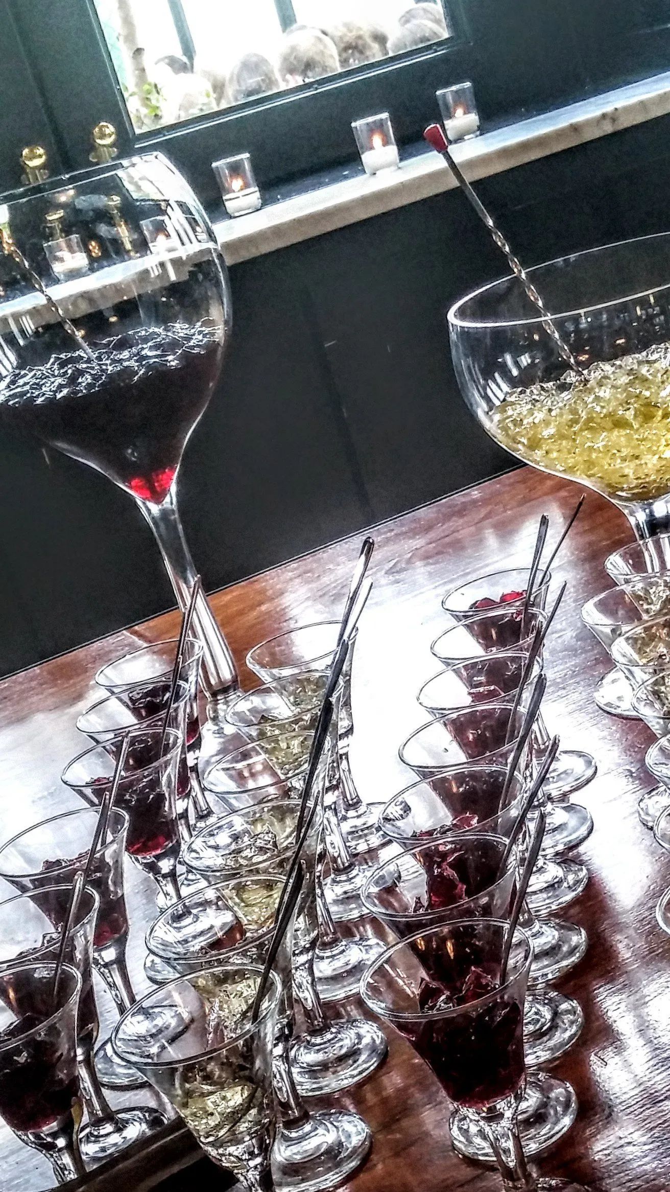 Wine glasses on a table with two appetizers on a white plate in a dim restaurant setting
