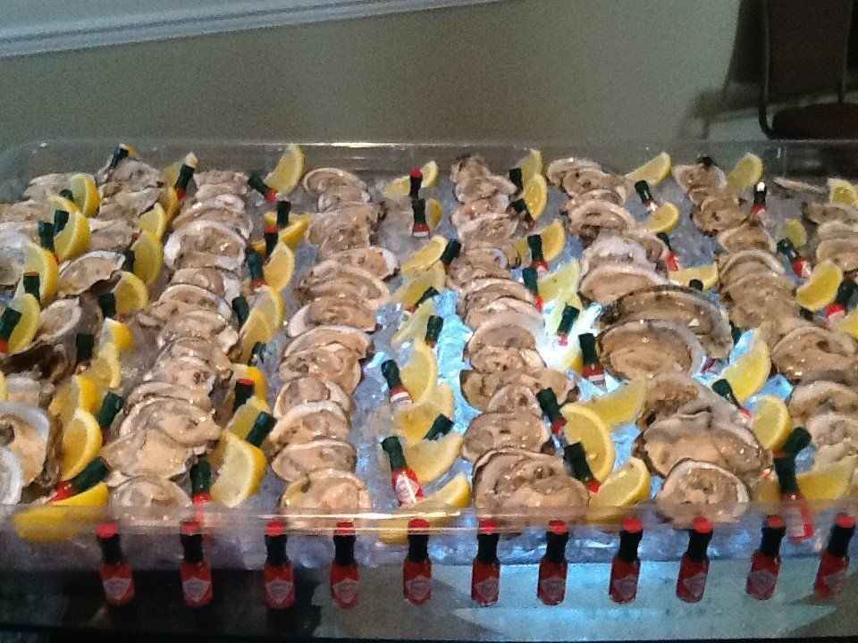 Rows of decorated trays with sandwiches and red cups arranged on a table for a catered event