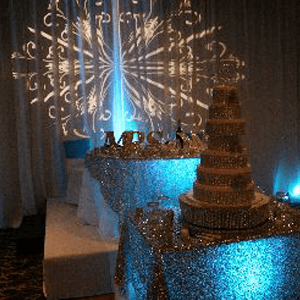 Sparkling dessert table with a tiered cake and blue lighting at a decorated celebration