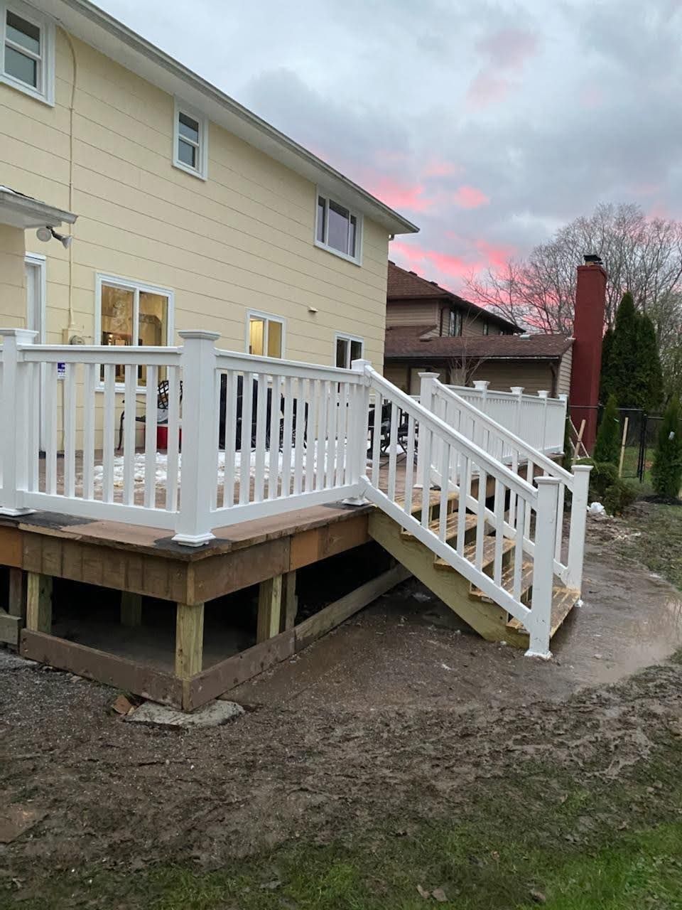 A house with a deck and stairs in front of it