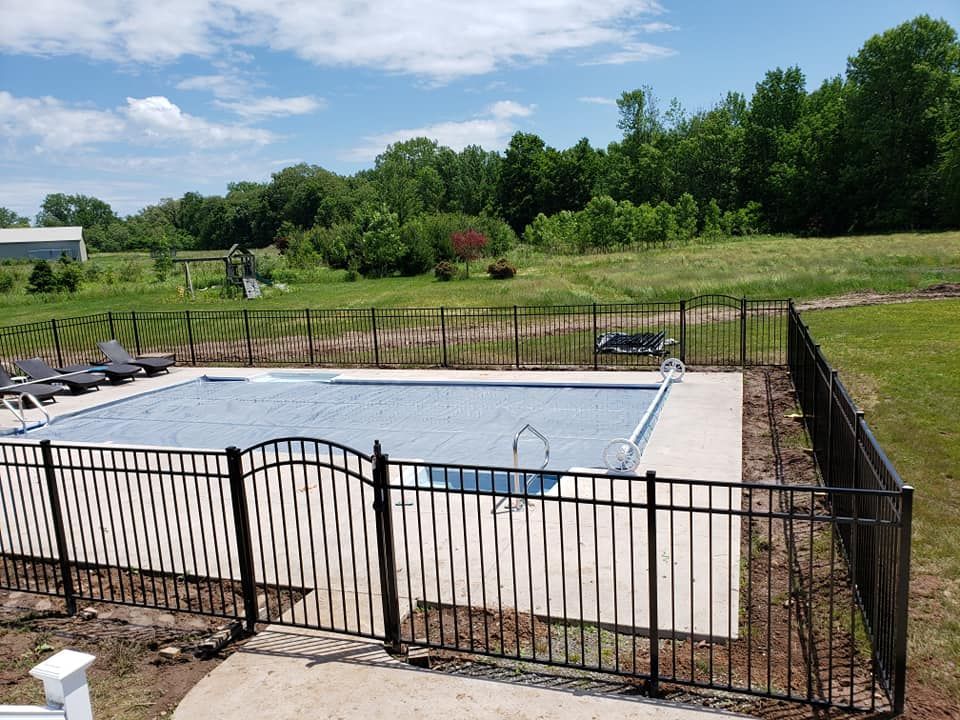 A large swimming pool with a black fence around it