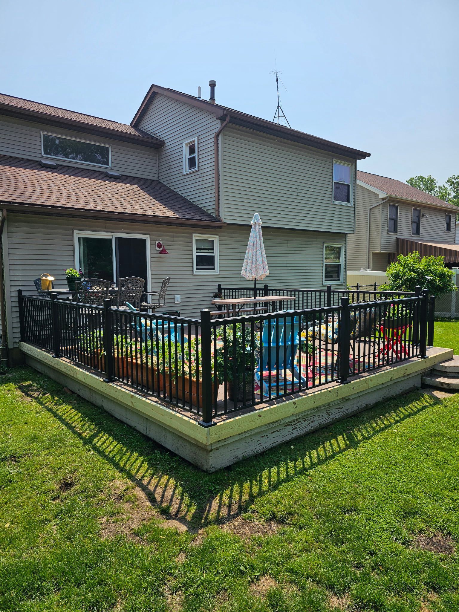 There is a large deck with a pool in the backyard of a house.