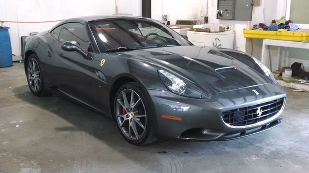Gray Ferrari California sports car in a garage.