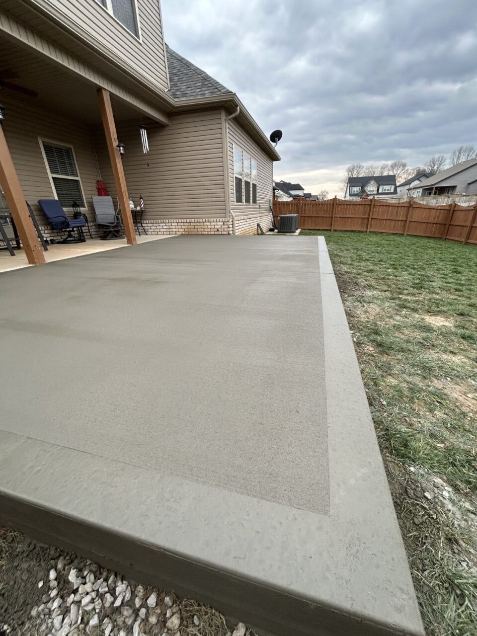 A concrete patio is being built in front of a house.