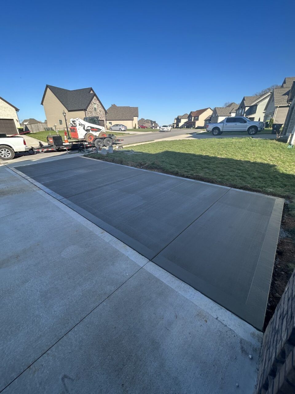 A concrete driveway is being built in a residential neighborhood.