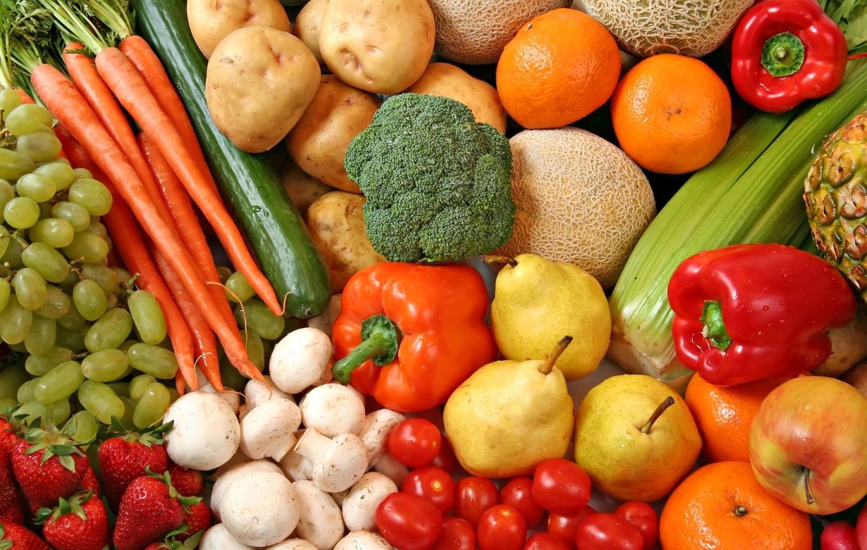 A variety of fruits and vegetables are displayed on a table.