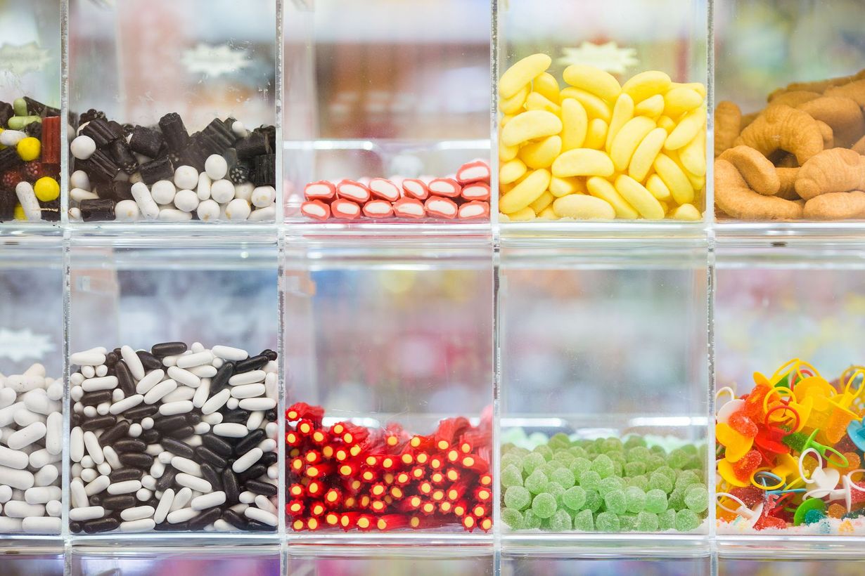 There are many different types of candy in these containers.