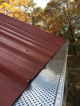 A red roof with a metal gutter on it.