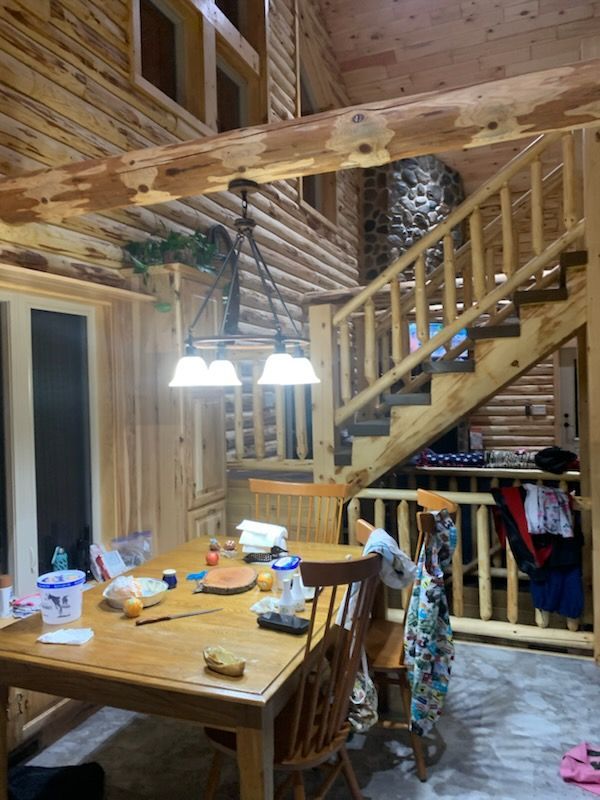 A wooden house with a table and chairs 