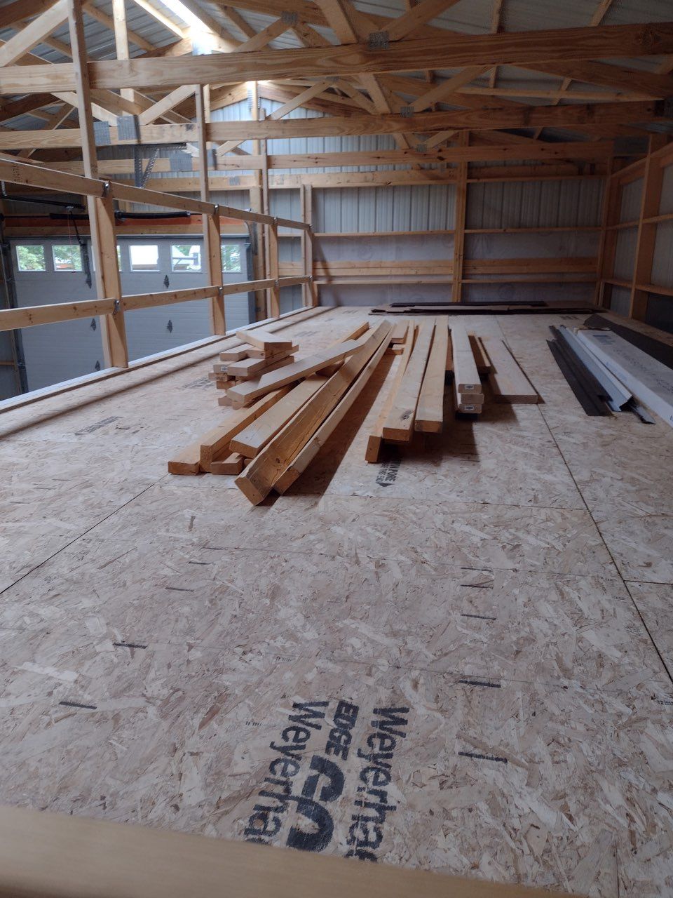 A shedunder construction with a lot of wood on the floor