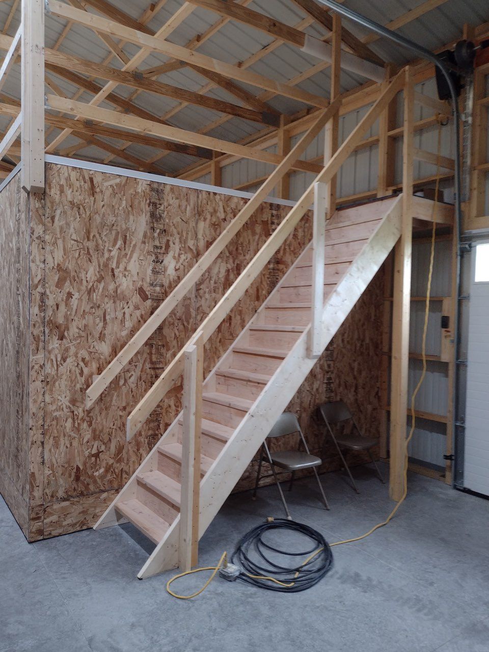 A wooden staircase is being built inside a shed