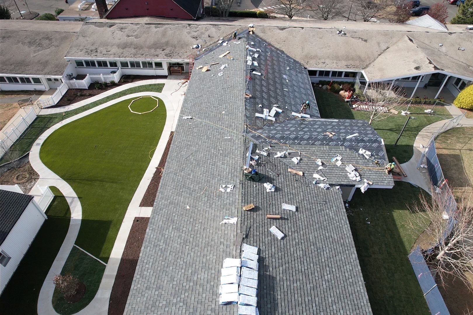 An aerial view of a house with a roof that is being repaired.