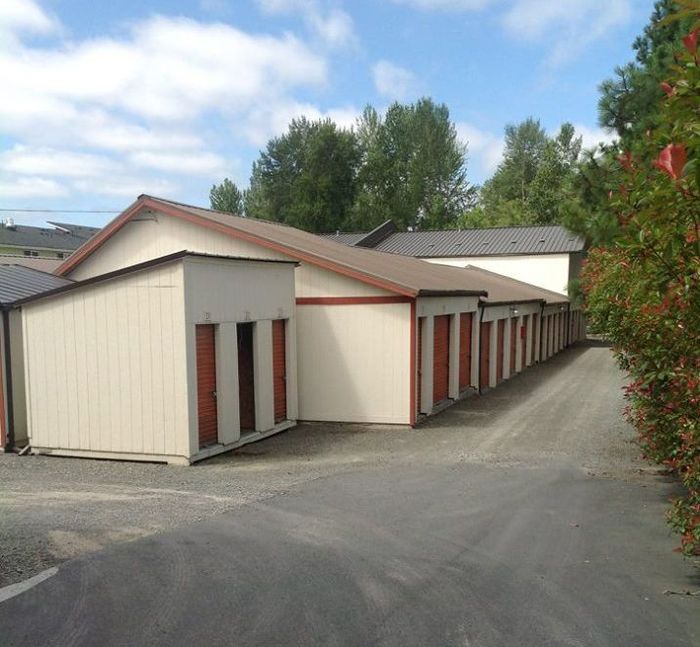 A row of storage units are lined up in a parking lot