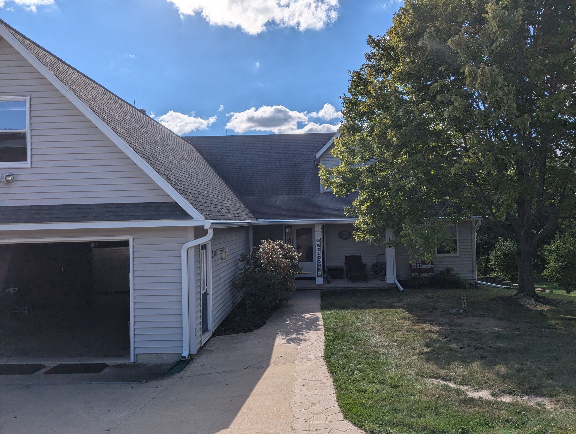 A two-story house with a garage and porch on a sunny day.