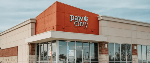 Exterior of a Pawny store with an orange facade and glass entrance in a strip mall