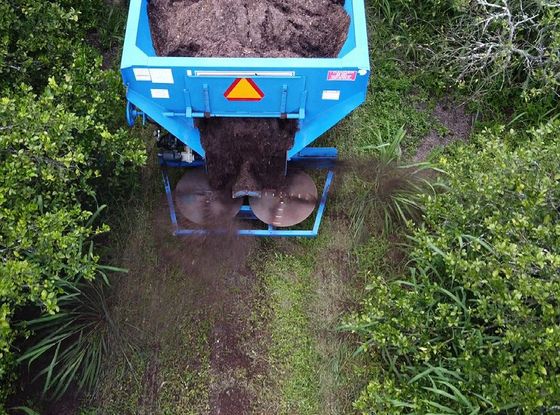 An aerial view of a blue trailer filled with dirt.