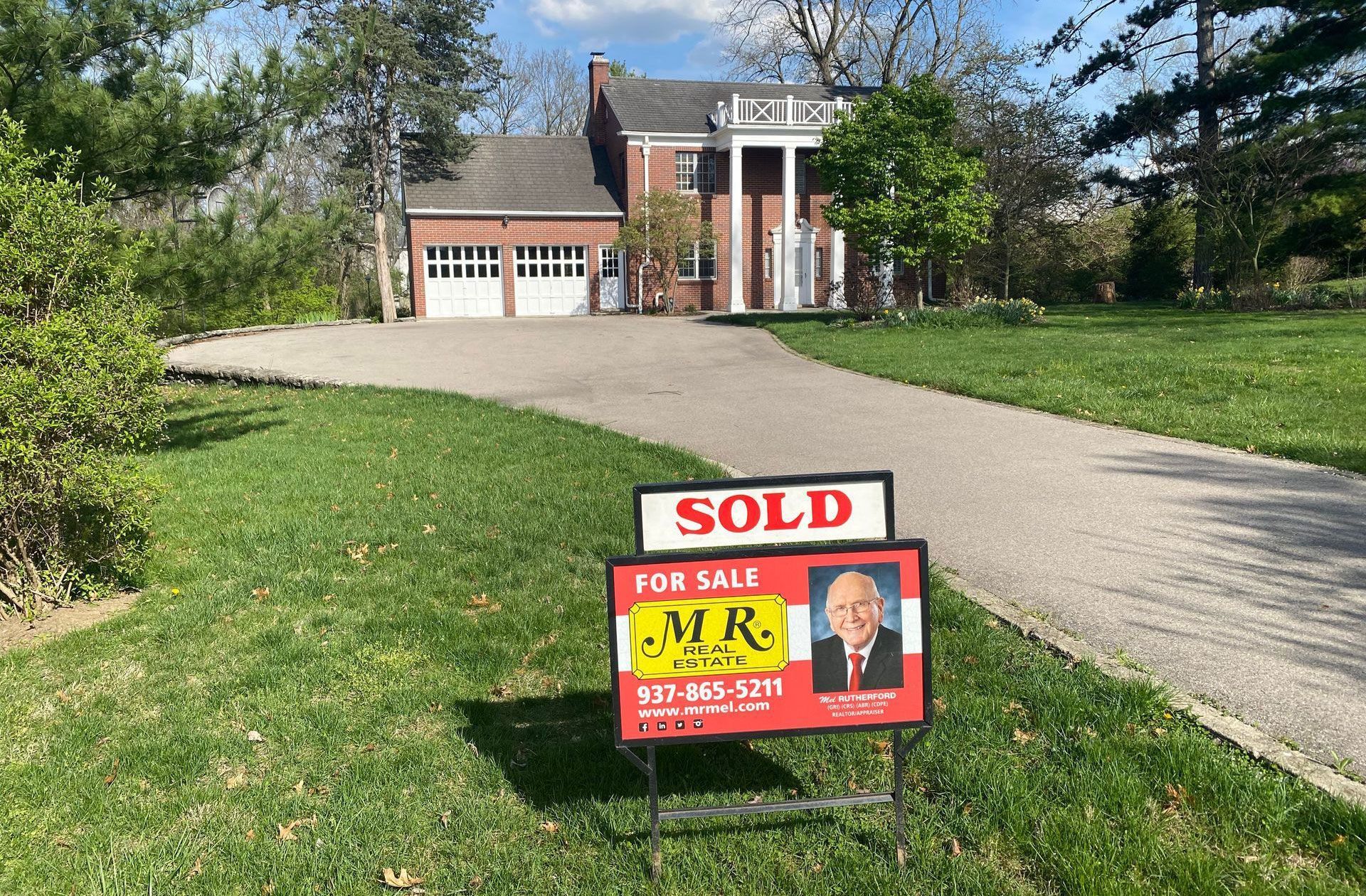 A large house with a sold sign in front 