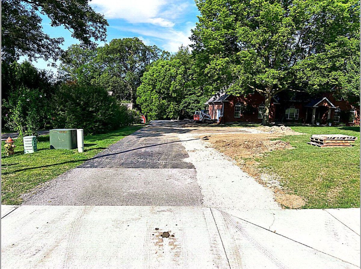A road going through a residential area with trees on both sides