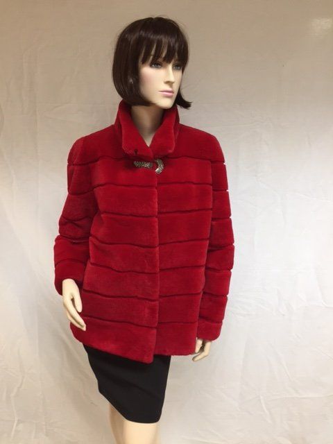 Red fur coat on a mannequin, black skirt, and white background.