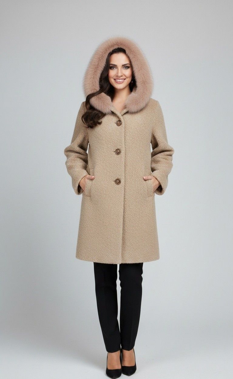 Woman in tan coat with fur-trimmed hood, black pants, and heels smiles.