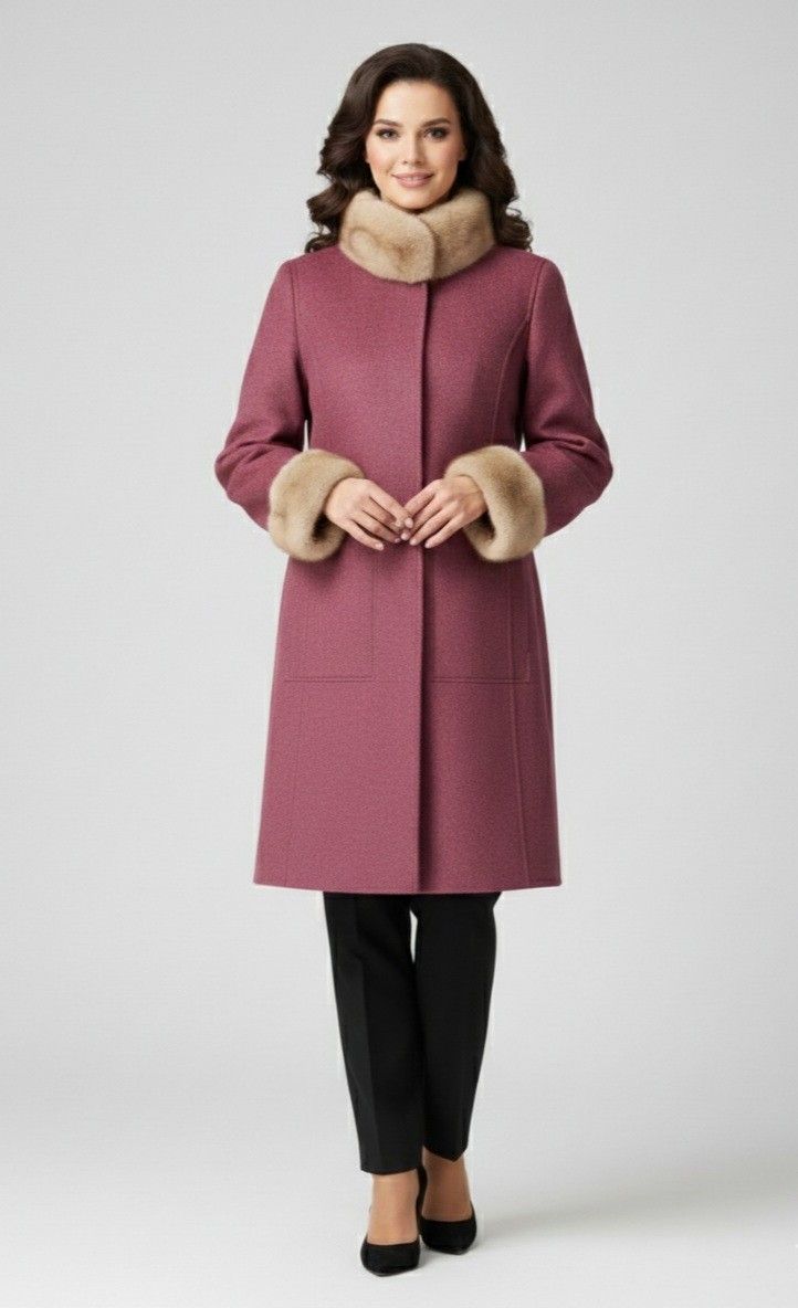 Woman in a maroon coat with fur collar and cuffs, black pants, and heels, in front of a gray backdrop.