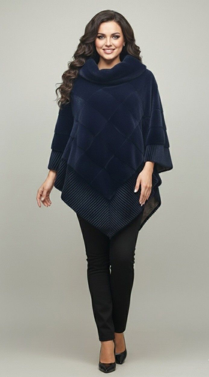 Woman in a navy blue fur poncho, black pants, heels, smiles, against a neutral background.