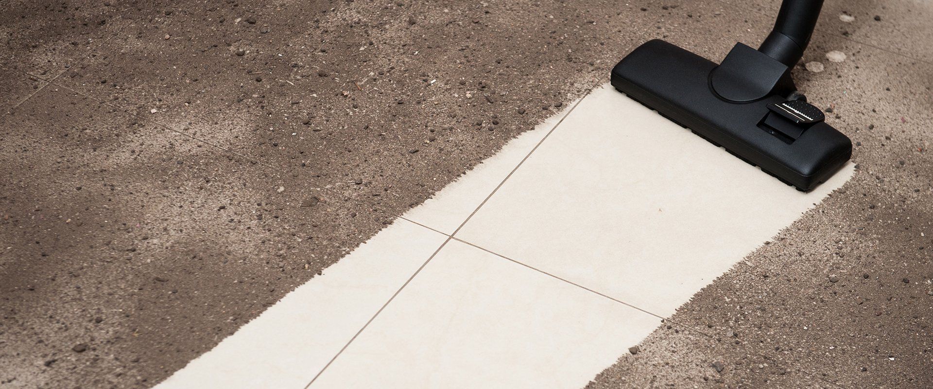 A vacuum cleaner is cleaning a tiled floor with a mop