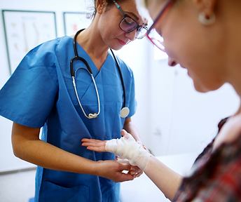 A nurse is bandaging a patient 's wrist in a hospital.