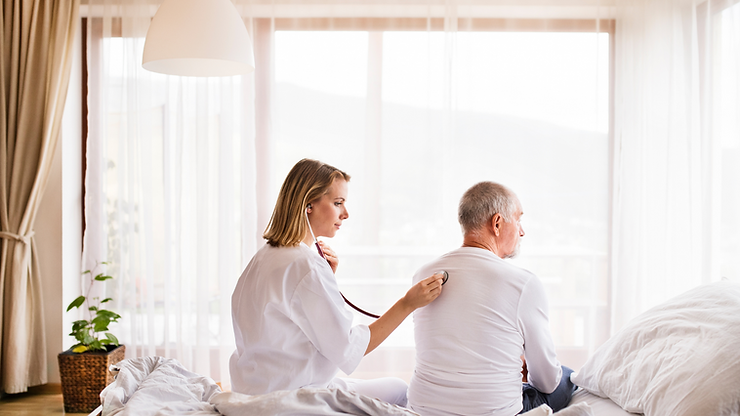 A nurse is listening to an older man 's heartbeat with a stethoscope.