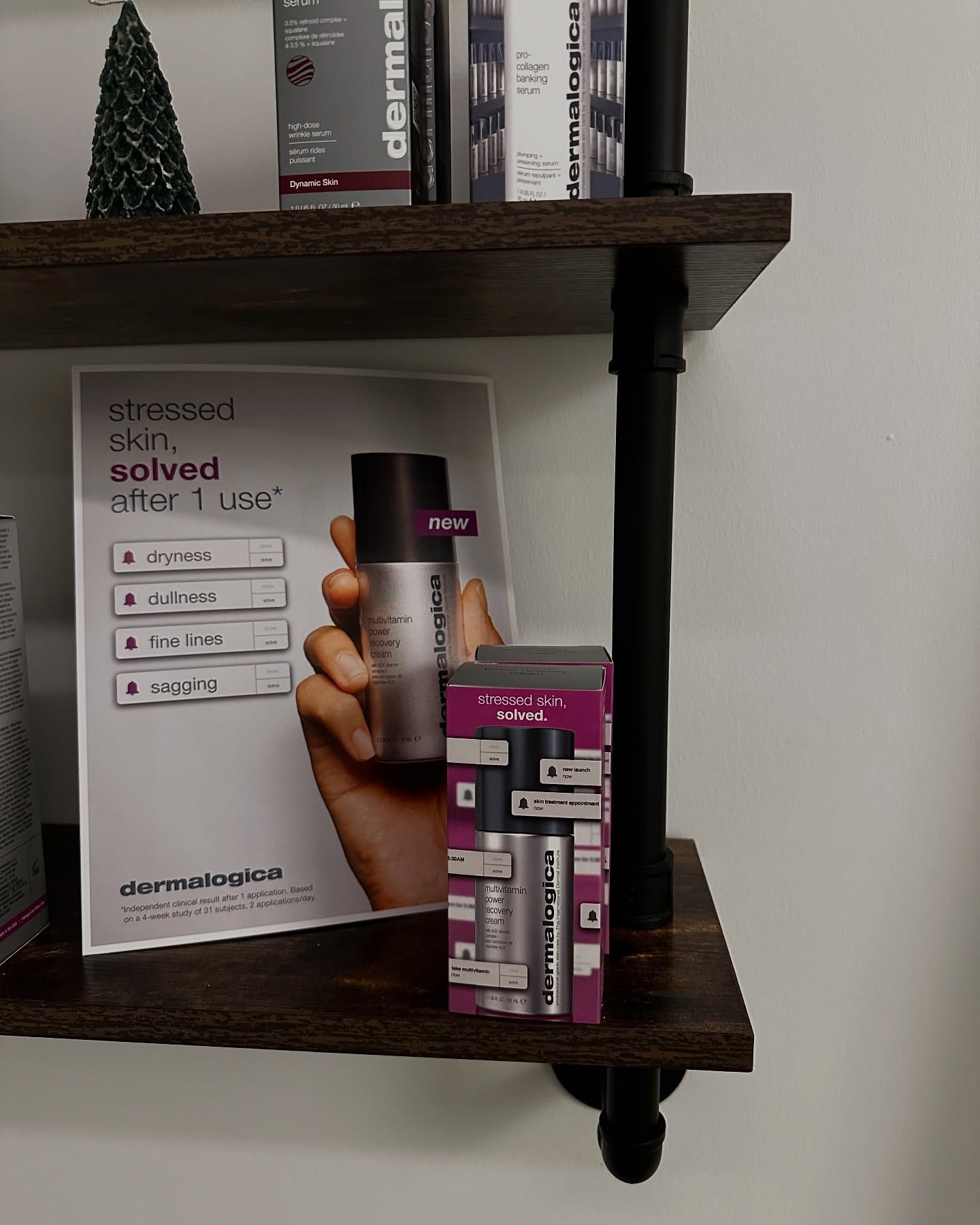 Shelf with skincare products and advertisement, hand holding a bottle.