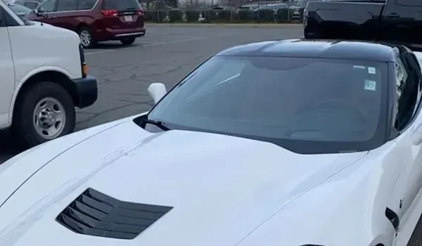 White Corvette sports car with a black roof parked outdoors.