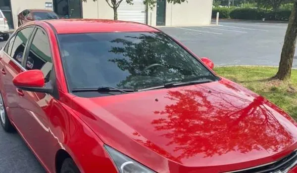 Red Chevrolet Cruze parked outside on a sunny day.