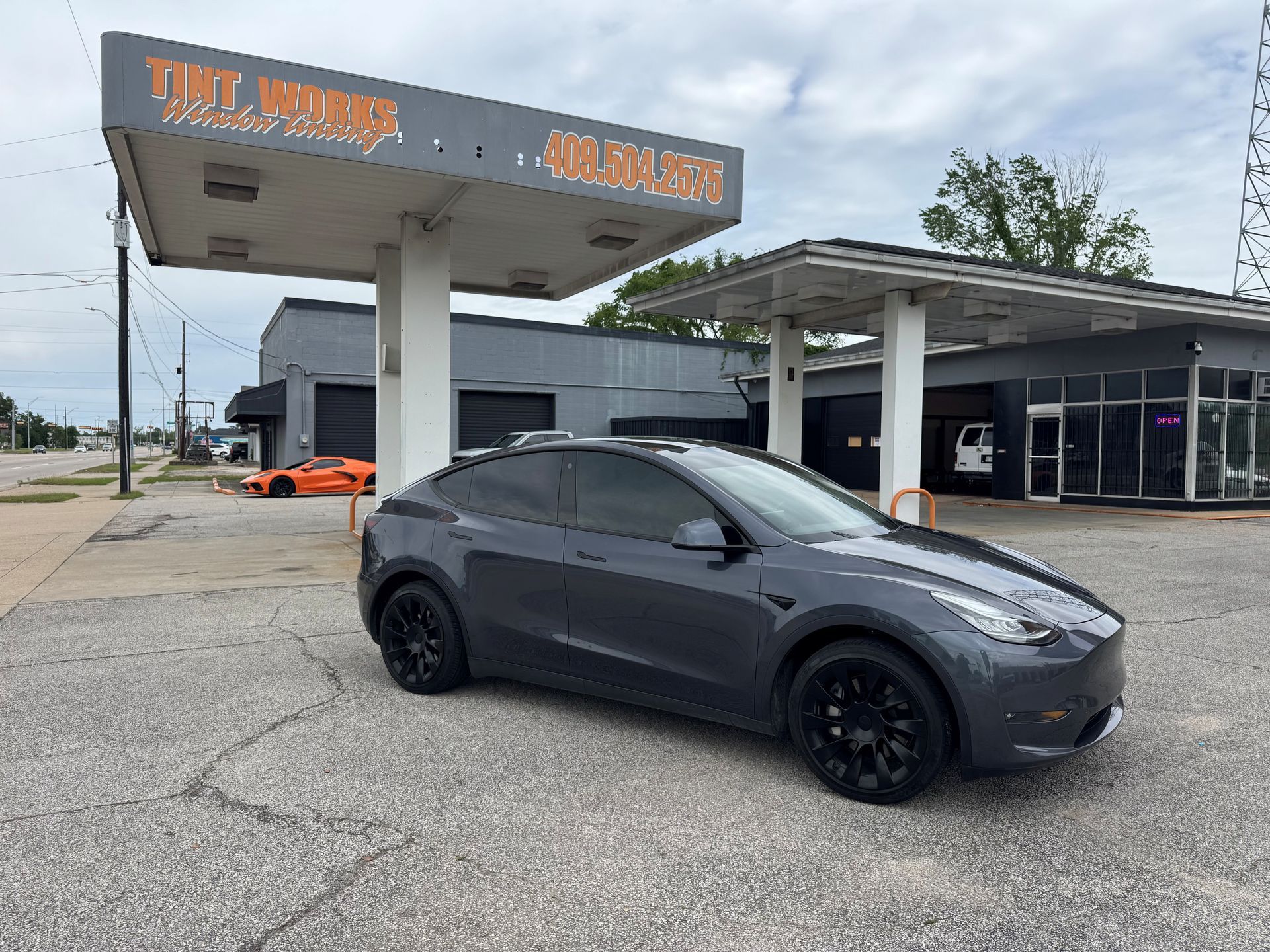 Dark gray SUV parked outside a car wash under a cloudy sky
