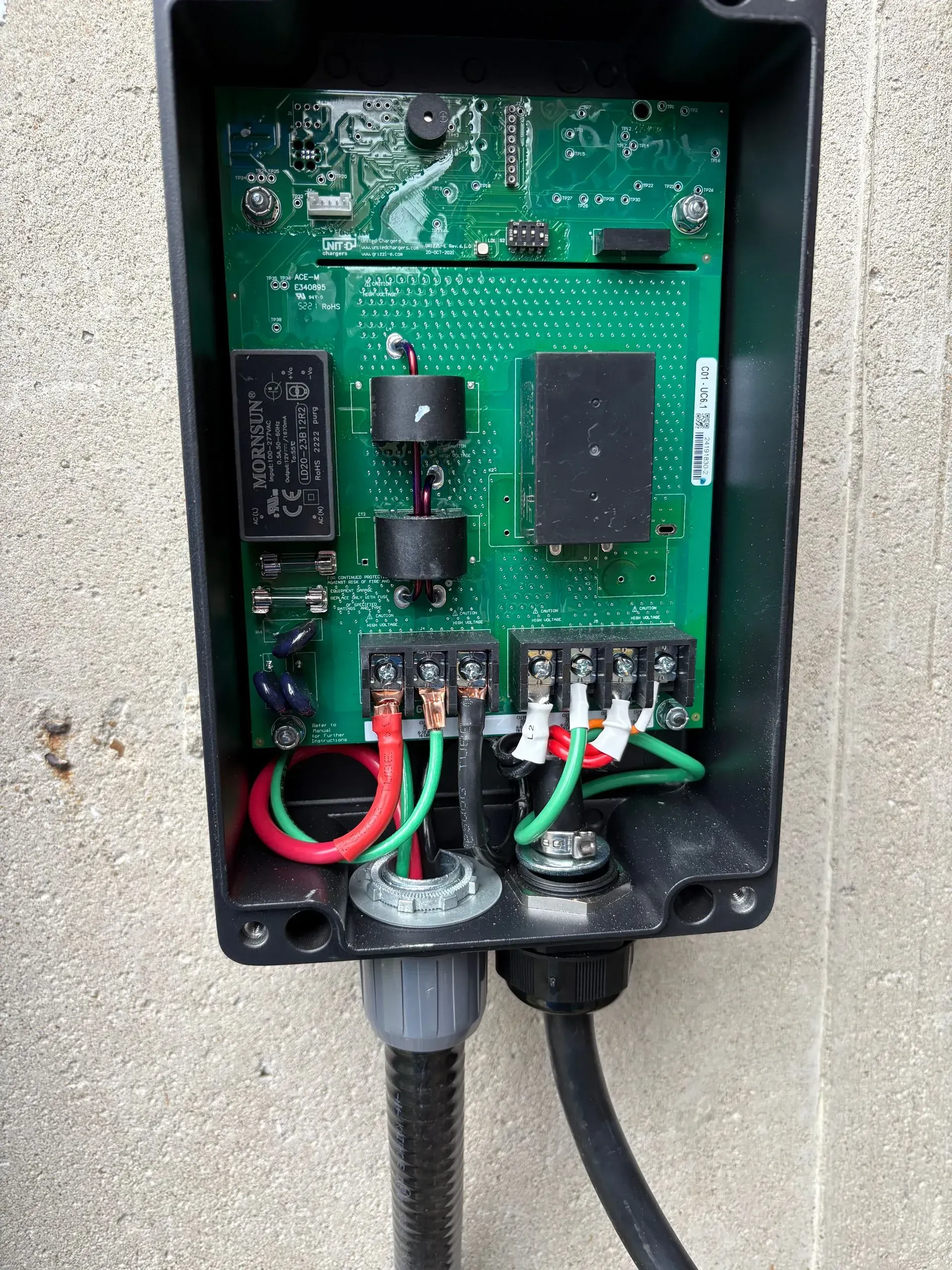 Open electrical box with circuit board, wiring, and conduit