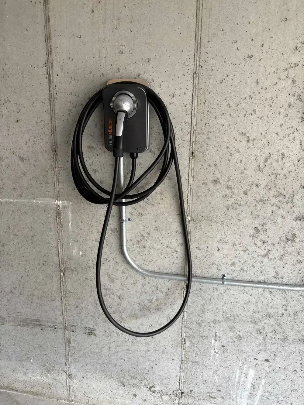 Electric vehicle charger mounted on a concrete wall