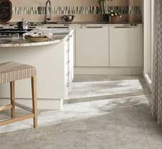 Kitchen with white cabinets, island, and light gray flooring.