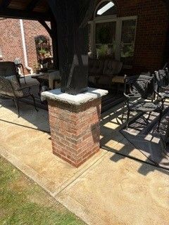 Brick porch with patio chairs and a covered outdoor seating area in sunlight