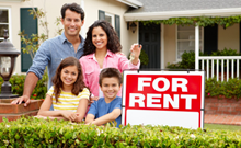 Family standing outside a house with a for rent sign