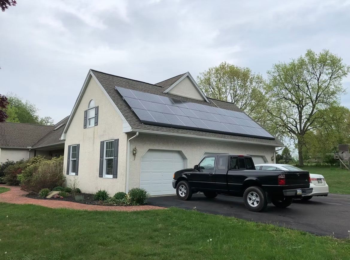Suburban house with solar panels on the roof and two vehicles parked in the driveway
